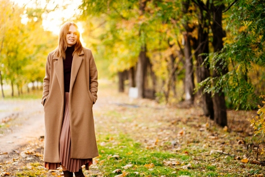 kobieta w płaszczu na spacerze w jesiennym parku